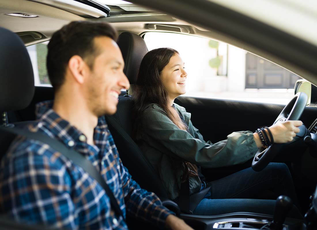 The Hanover SafeTeen Program - Happy and Smiling Dad With His Teenage Girl Practice Safe Driving Together in Preparation for Her Drivers License Test