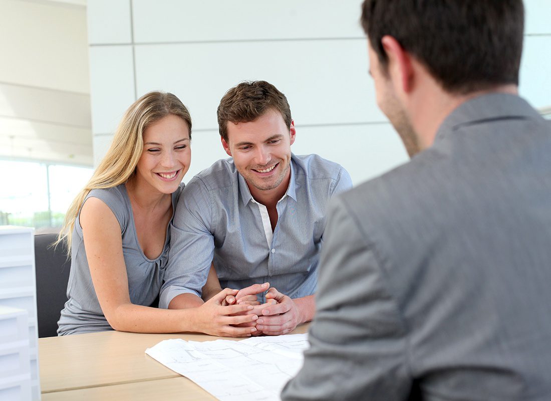 Contact - Happy Couple Sit and Talk With an Agent in an Office
